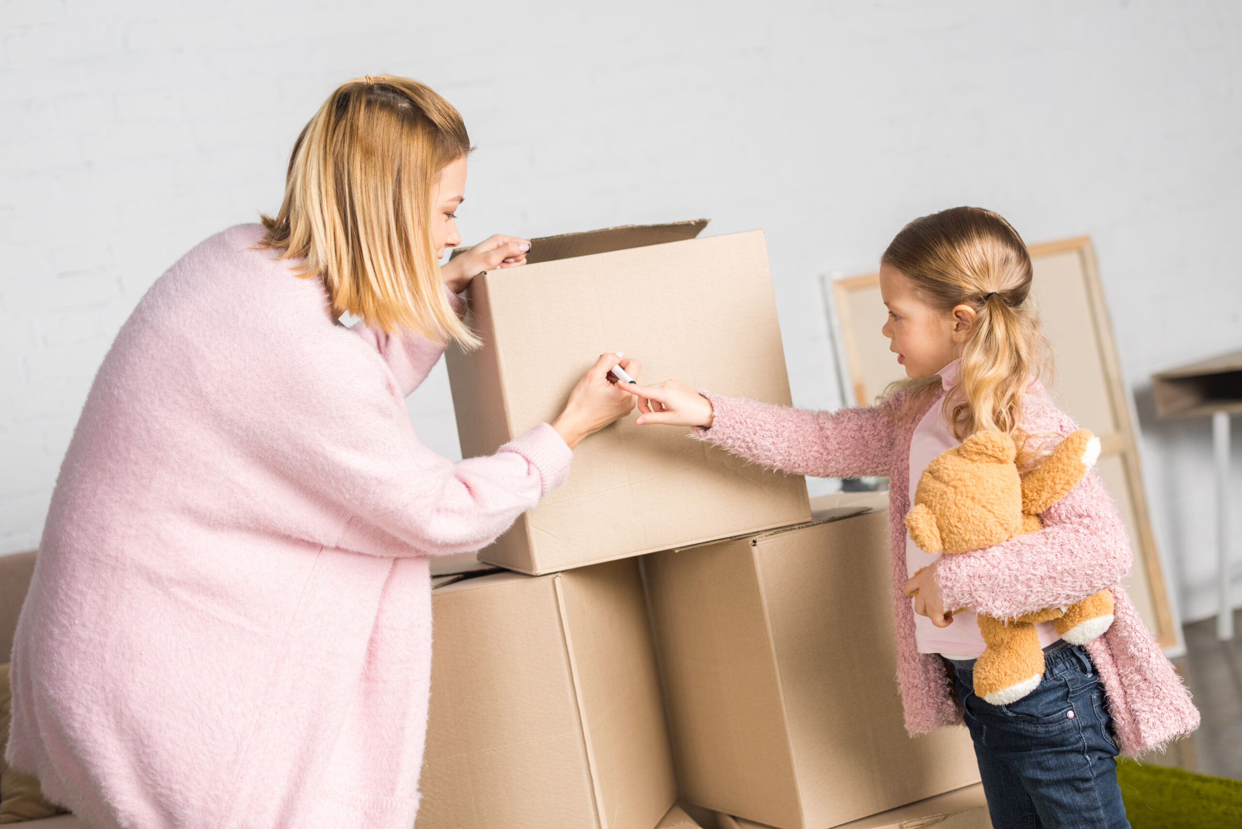 mother and daughter packing boxes for a move